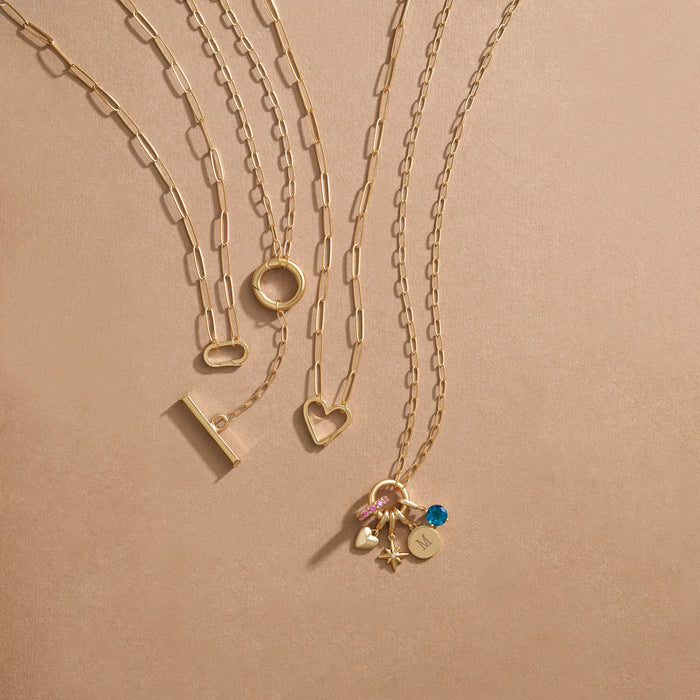 Gold charm necklaces with paperclip style links and different shaped charm bails.