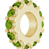 Gold charm with light green gemstones on a white background