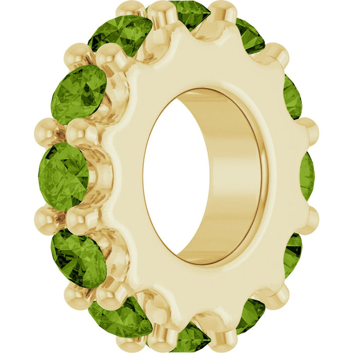 Gold charm with light green gemstones on a white background