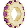 Gold charm with pink gemstones on a white background