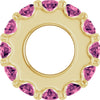 Gold charm with pink gemstones on a white background