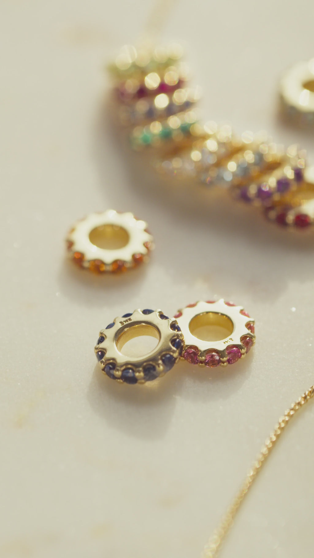 Video of gemstone slider charm pendants being put on gold chain on model