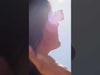 Video of woman wearing gold charm paperclip necklace in the sunshine