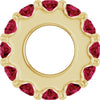Gold charm with red gemstones on a white background