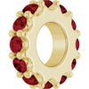 Gold charm with red gemstones on a white background