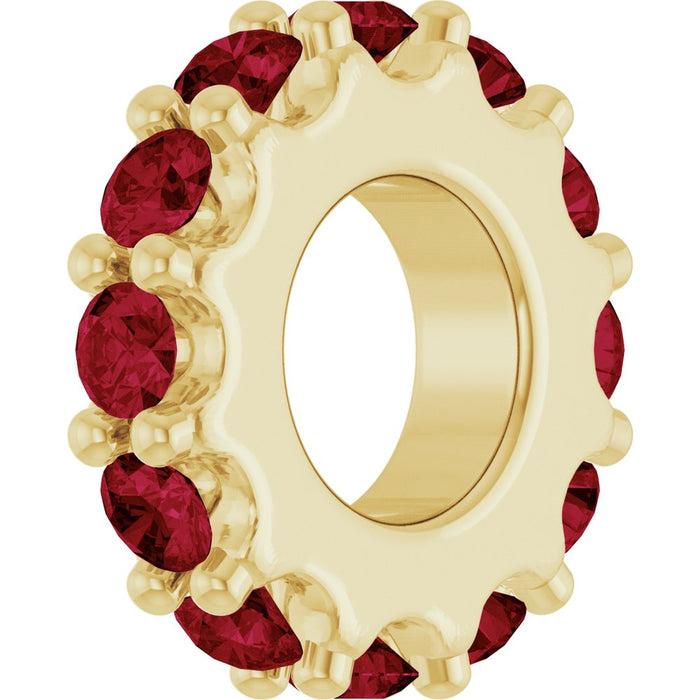 Gold charm with red gemstones on a white background