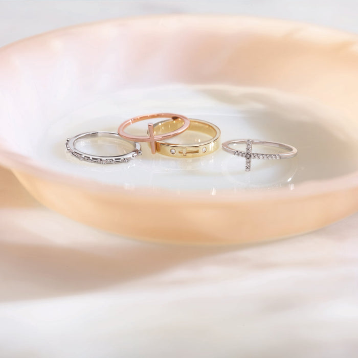 Sideways diamond cross rings on a white dish with a soft focus background
