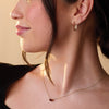 Woman wearing red stone gemstone pendant gold necklace
