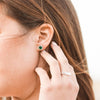 Model wearing Statement Birthstone Emerald and Natural Diamond Halo Sterling Silver Earrings