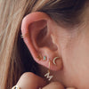 Model's curated ear shows our Zodiac Stud earring in solid 14K Yellow Gold 