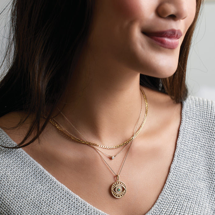 Model Wearing Evil Eye Natural Turquoise & Diamond Charm Pendant Solid 14K Yellow Gold Layered With Curb Chain and Diamond Solitaire Necklaces
