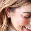 Model wearing Rainbow Natural Round Gemstone Wear Everyday™ Huggie Hoop Earrings 14K Yellow Gold