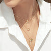 Model wearing solid gold rainbow charm pendant in 14K yellow gold