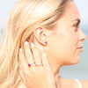 Model wearing matching jewelry set Round Statement Birthstone Ruby & Diamond Halo Sterling Silver Earrings & Ring