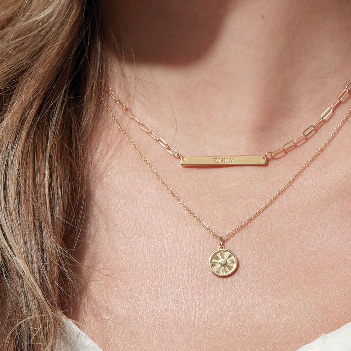 Model wearing our Sun Disc Starburst Necklace with Paperclip Nameplate Necklace in 14K Yellow Golf