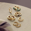 A collection of solid gold hoop earrings and ear cuffs