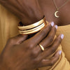 Model wearing our Wear Everyday™ Gold Bangle Bracelets and Petite Dome Solid Gold Ring in 14K Yellow Gold